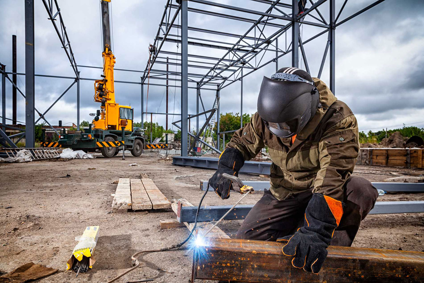 A man welding at a construction site.